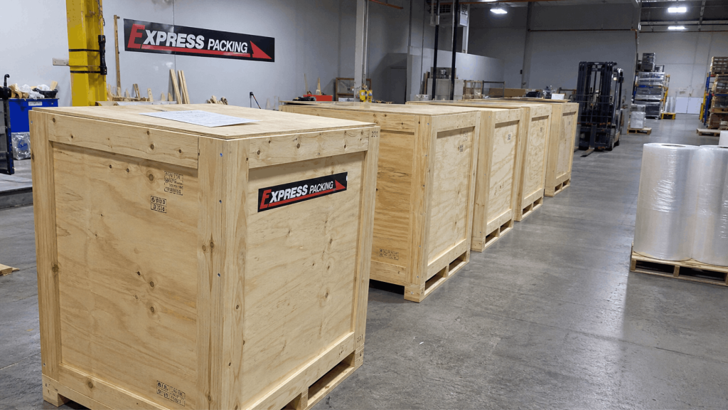 Custom wood shipping crates pre-built and staged at an Express Packing facility as part of an on-demand crate stocking and PO release program for industrial manufacturers.